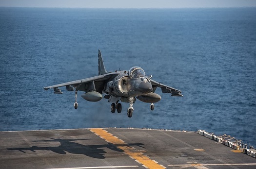 a picture of a fighter jet landing on an aircraft carrier