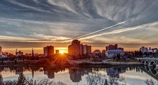 a picture of the sun setting on the skyline of Saskatoon
