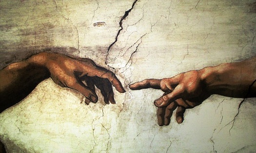 a picture of two index fingers about to touch in Michaelangelo's famous creation painting