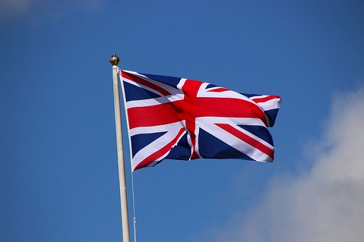 a picture of a flag pole with the union jack waving in the wind