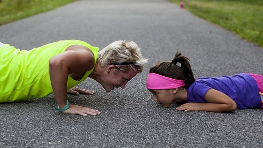 a picture of a mother and daughter doing push ups